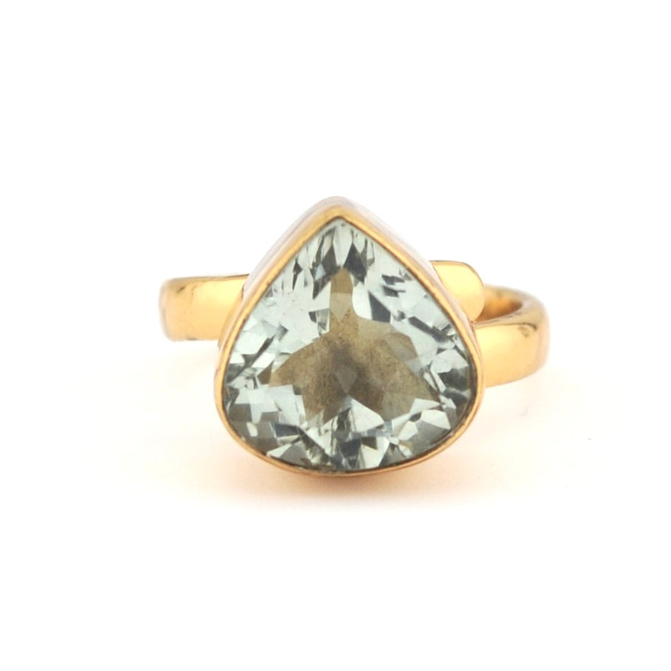Gold ring with a green gemstone on a white background