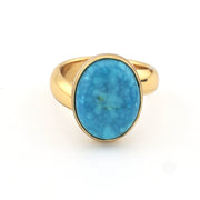 Turquoise and gold ring on white background