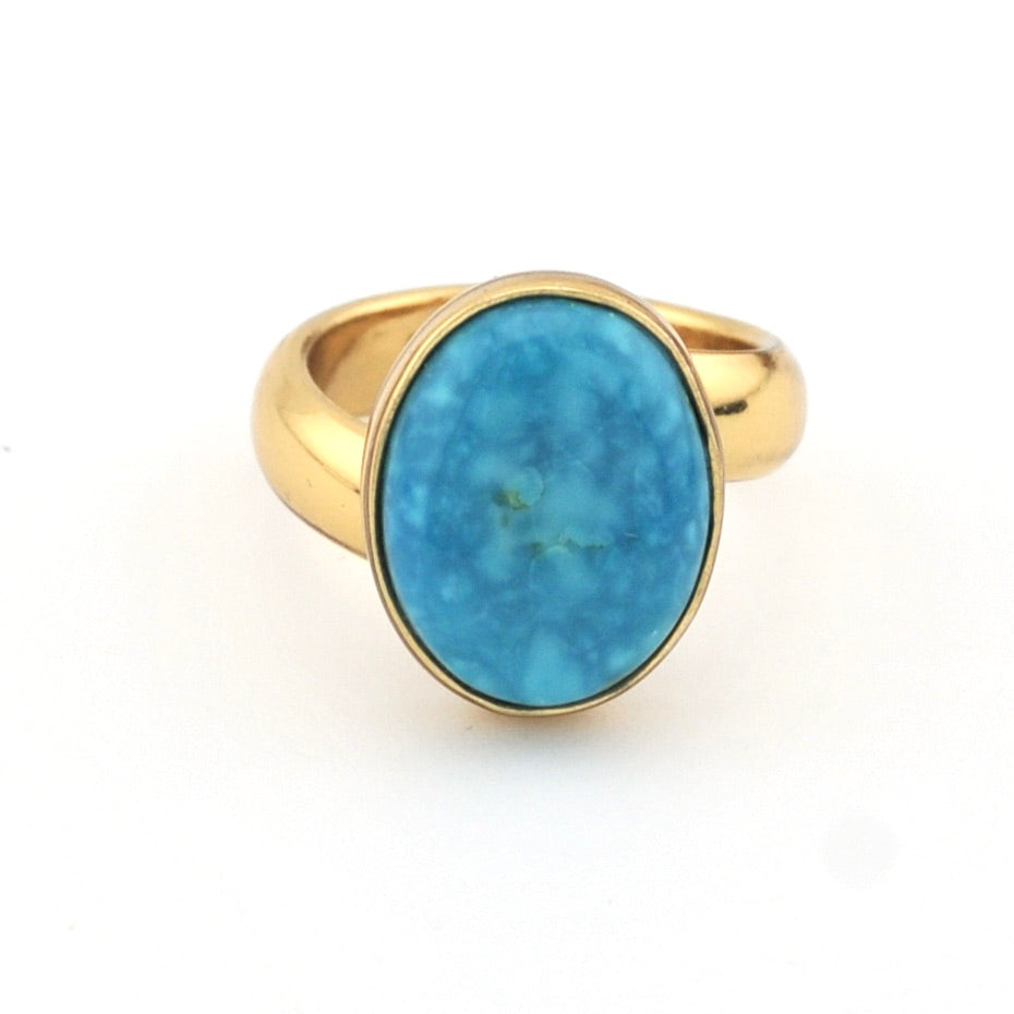 Turquoise and gold ring on white background