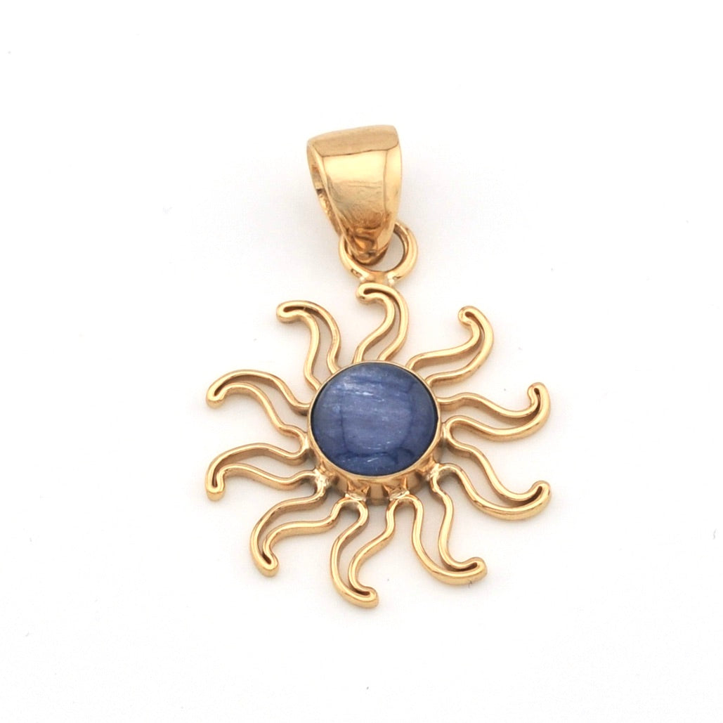 Gold sun-shaped pendant with a blue gemstone on a white background