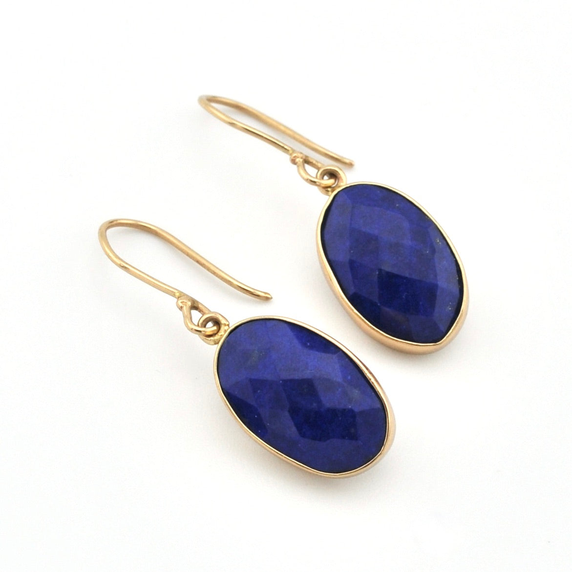 Gold earrings with blue stones on a white background