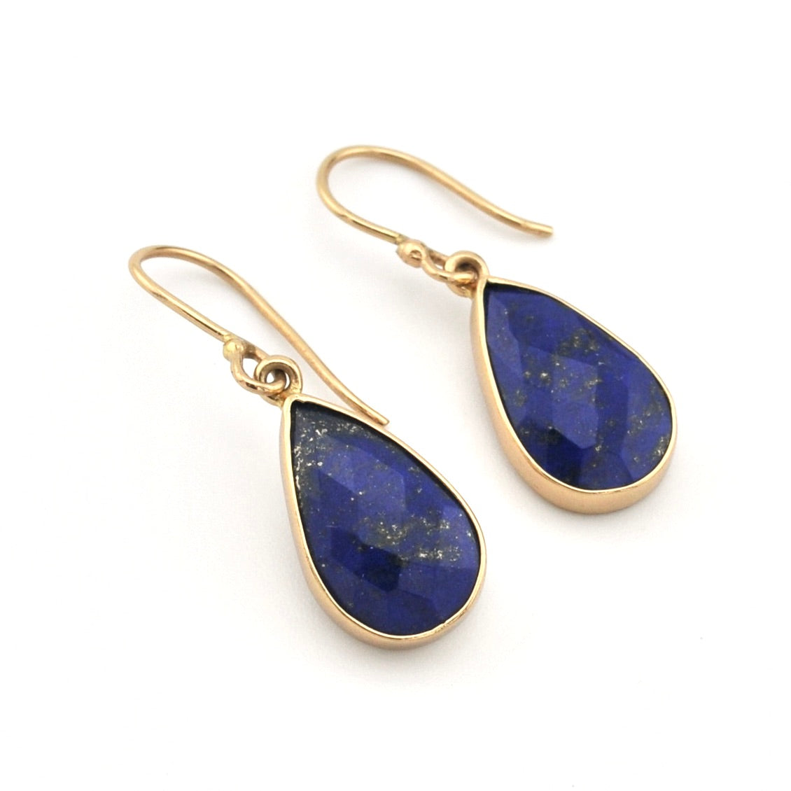 Gold earrings with blue teardrop-shaped stones on a white background
