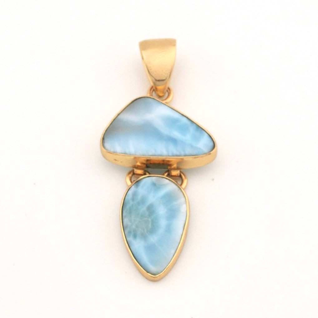 Gold pendant with two blue larimar stones on a white background