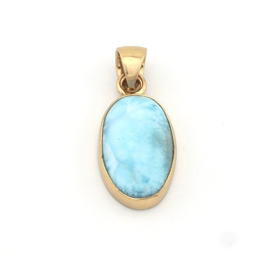 Gold pendant with a blue larimar stone on a white background