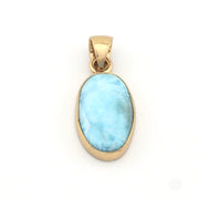 Gold pendant with a blue larimar stone on a white background