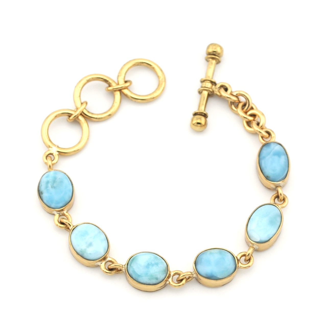 Gold bracelet with light blue gemstones on a white background