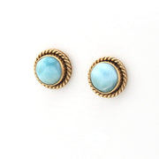 Pair of earrings with gold rims and light blue gemstones on a white background