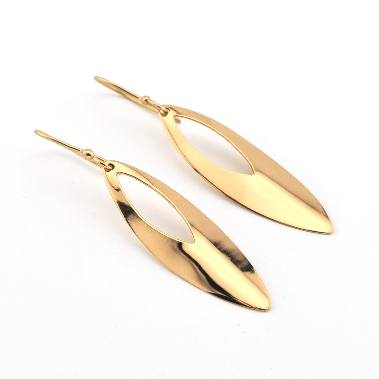 Gold leaf-shaped earrings on a white background