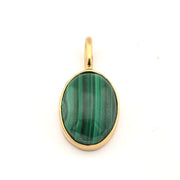 Gold pendant with a green stone on a white background