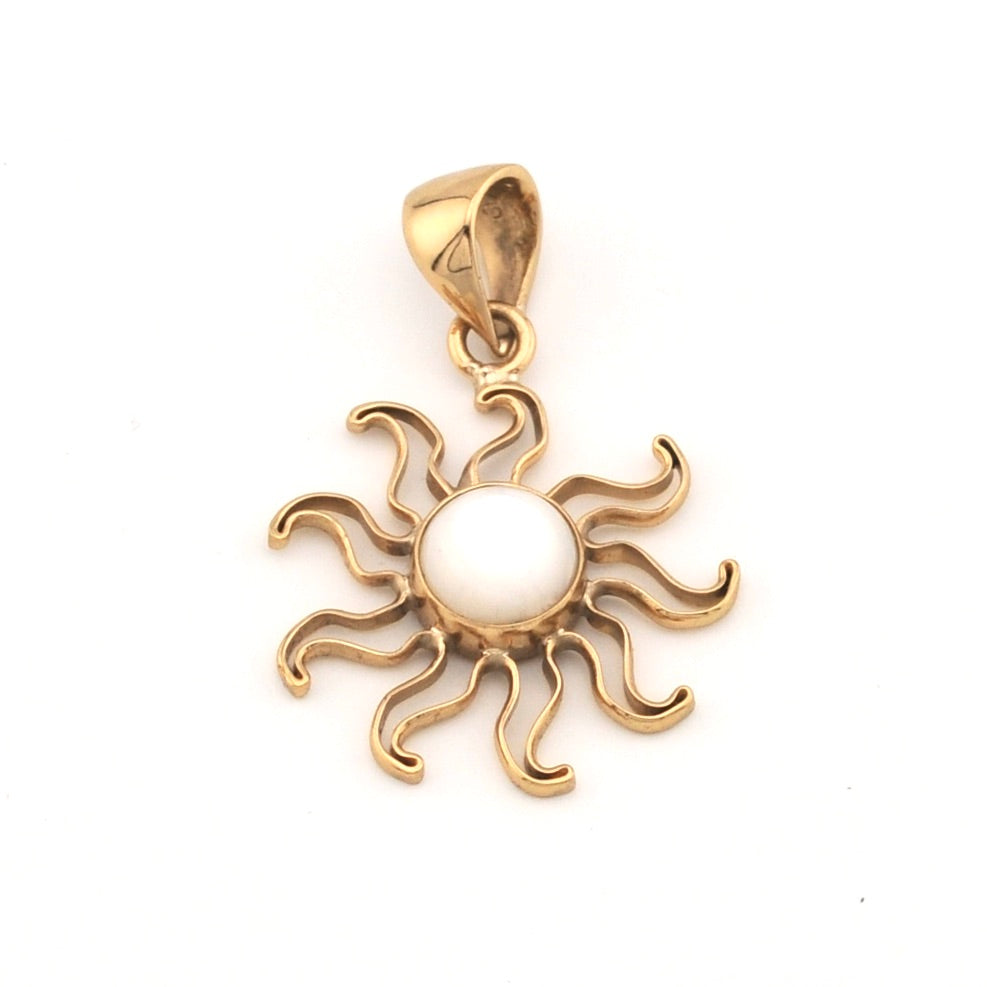 Gold sun-shaped pendant with a white center on a white background
