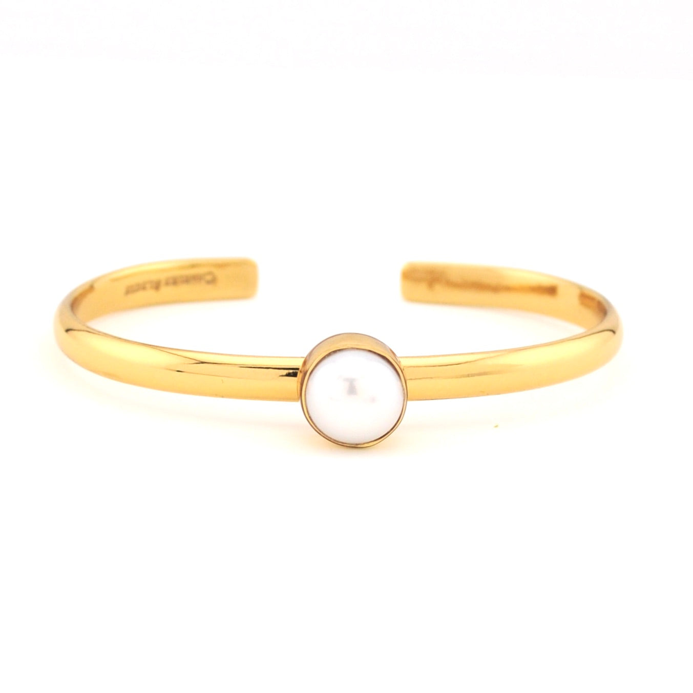 Gold bracelet with a central pearl on a white background