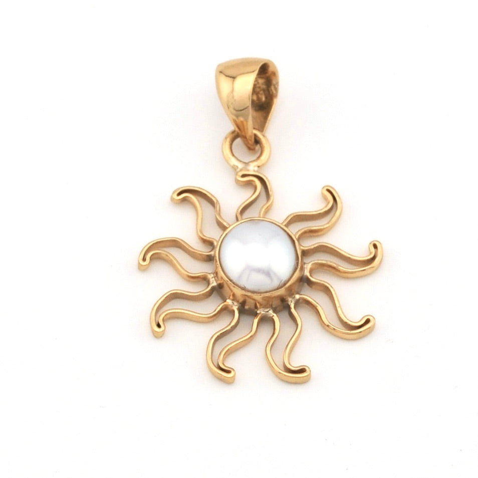 Gold sun-shaped pendant with a central pearl on a white background