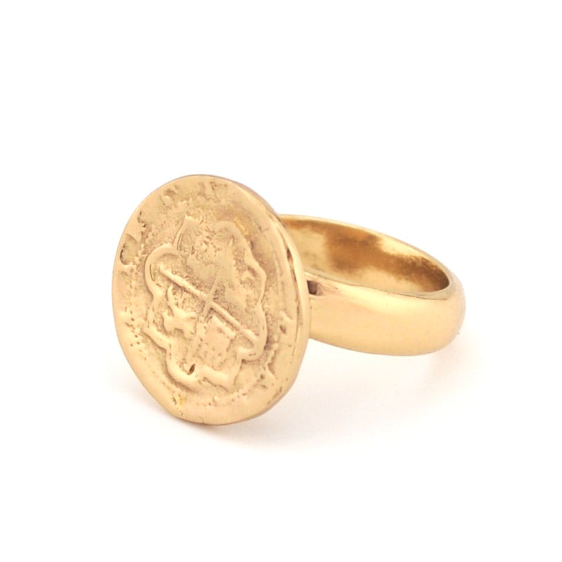 Gold ring with a circular coin on a white background