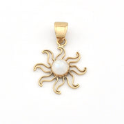 Gold sun-shaped pendant with a central pearl on a white background