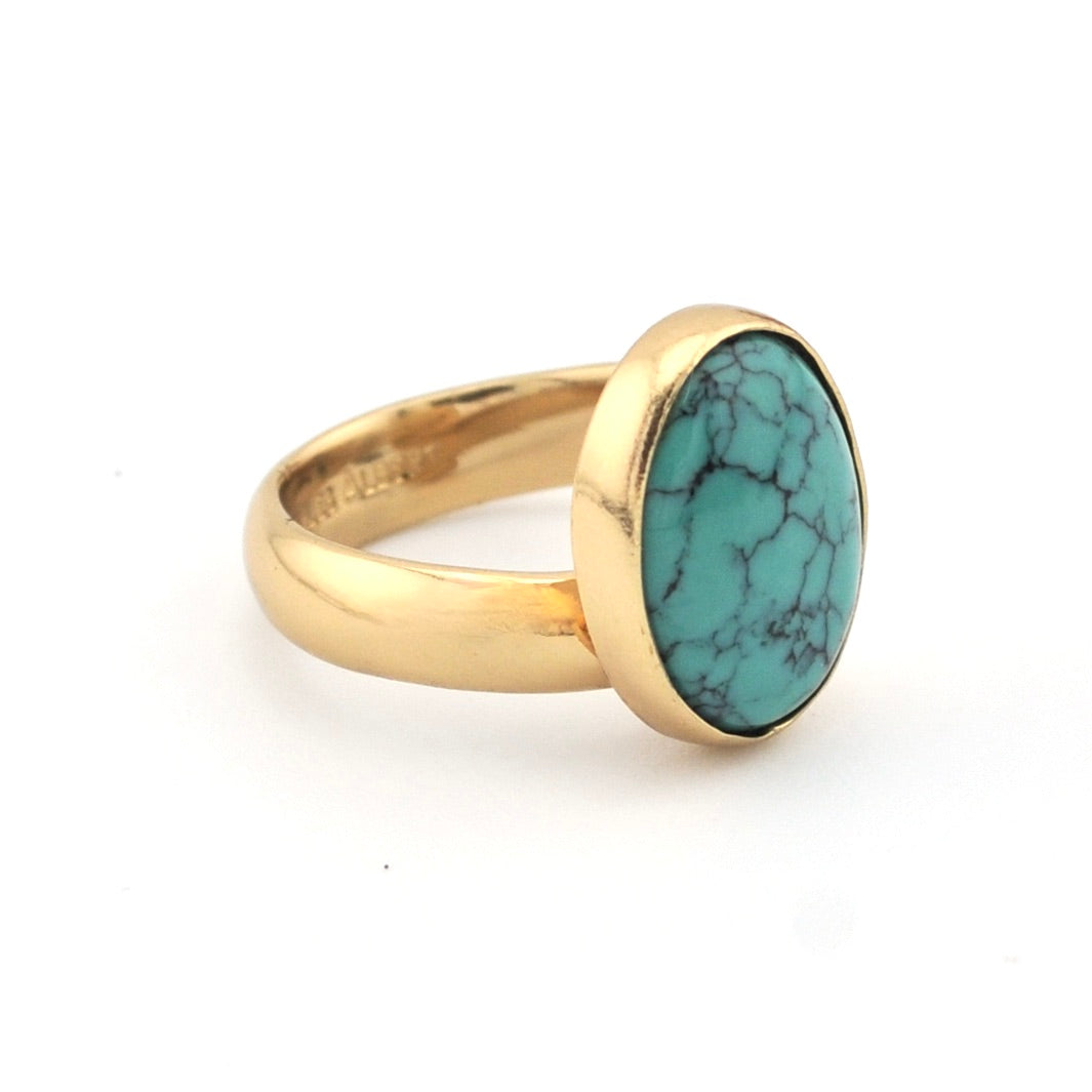 Gold ring with turquoise on white background