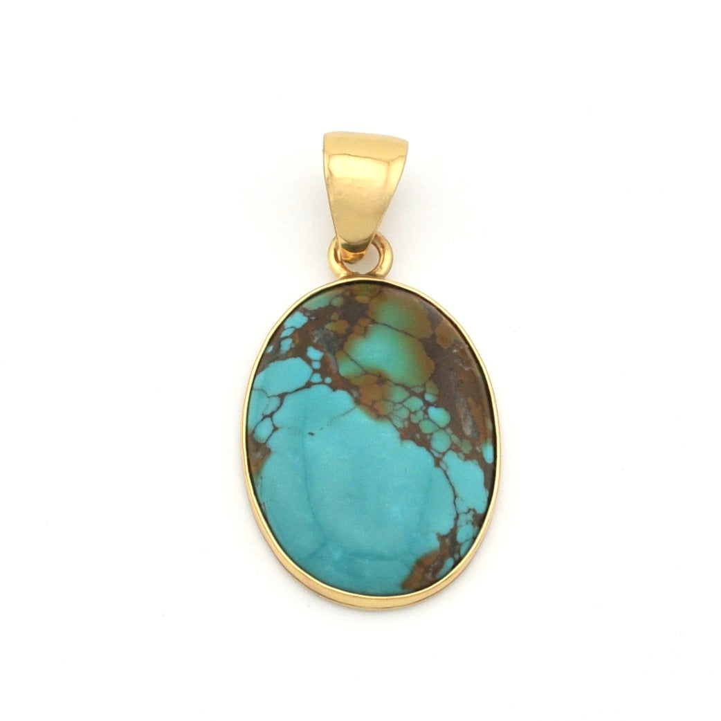 Turquoise pendant with gold setting on a white background