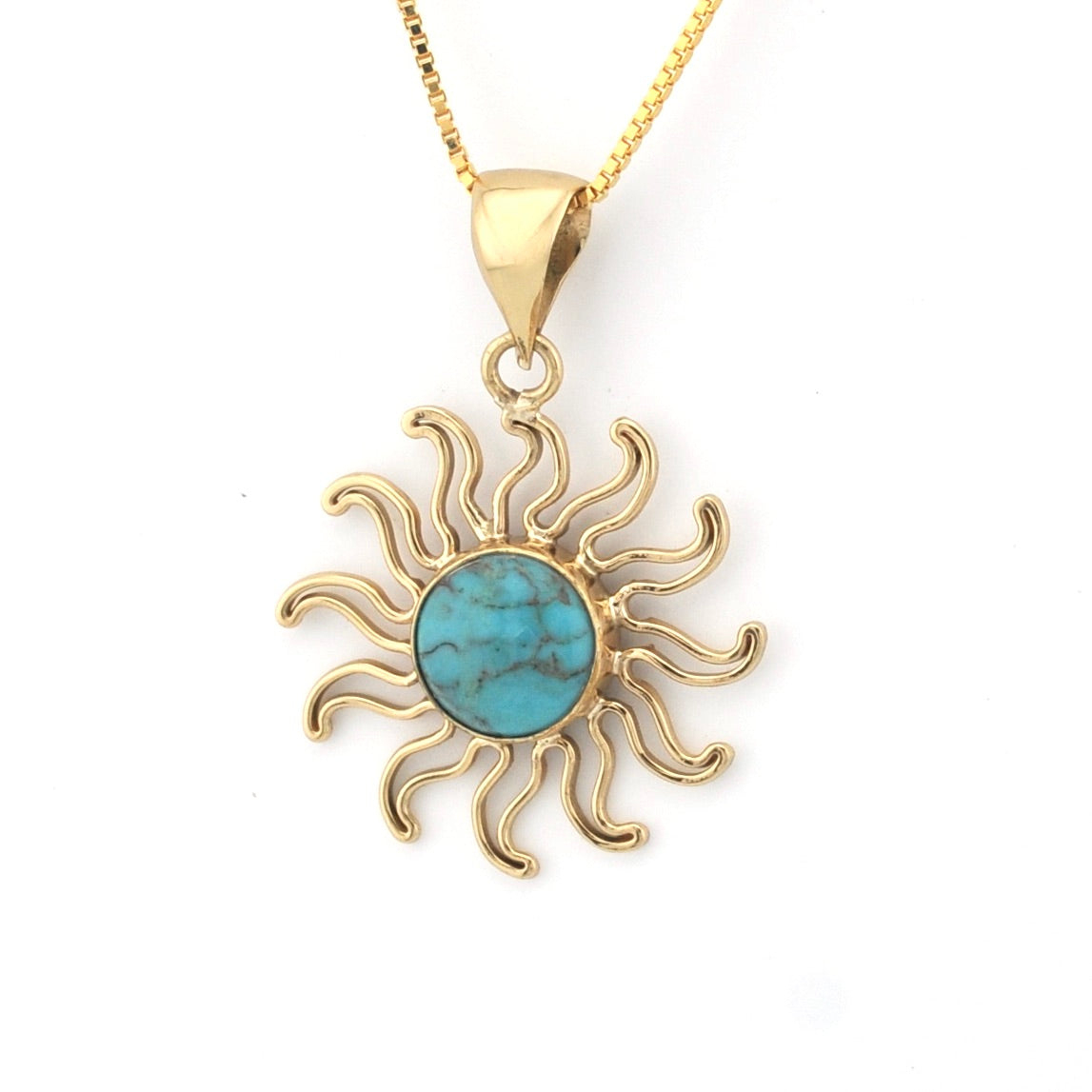 Gold sun-shaped pendant with turquoise center on a white background