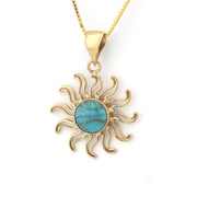 Gold sun-shaped pendant with turquoise center on a white background