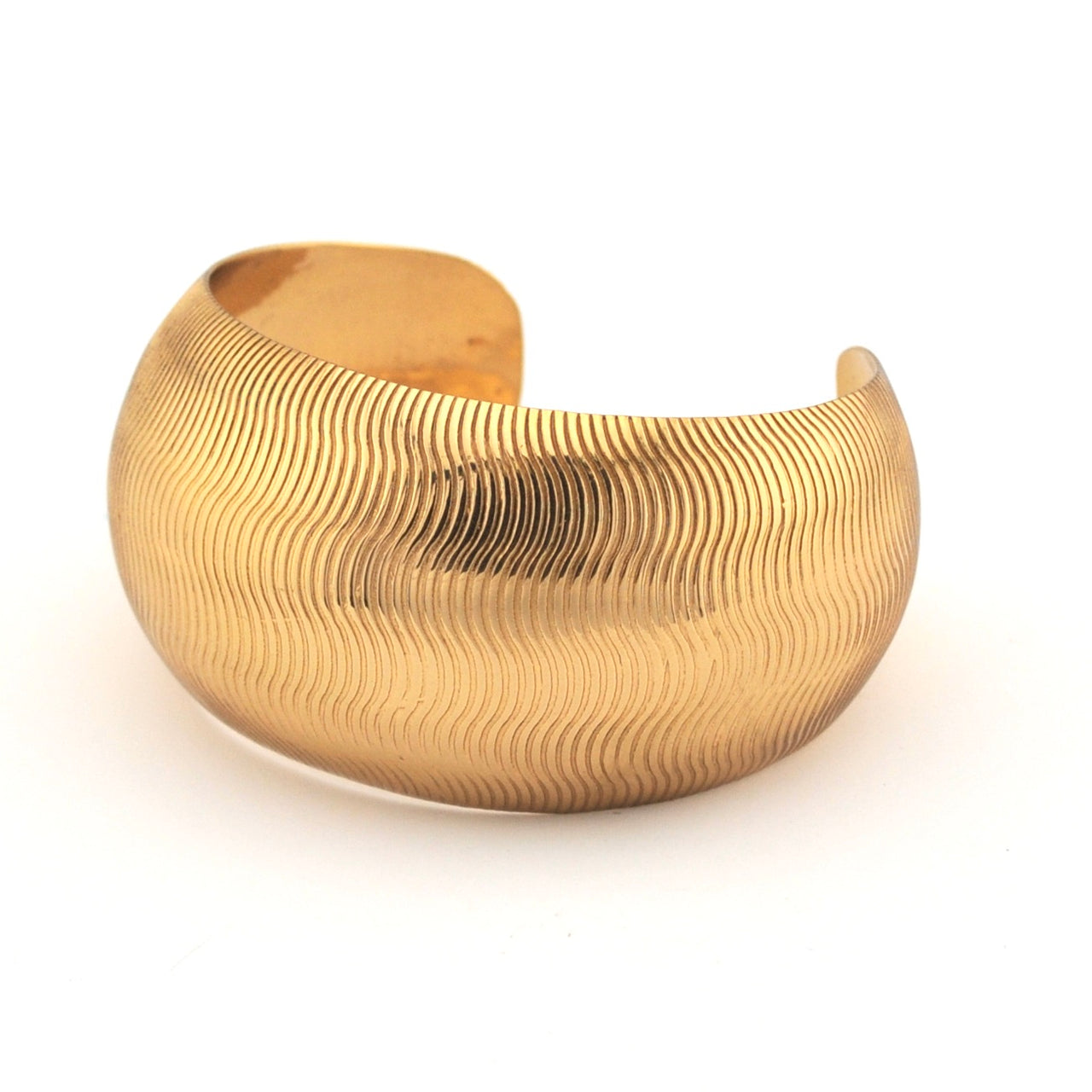 Gold textured bracelet on a white background