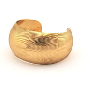 Gold textured bracelet on a white background