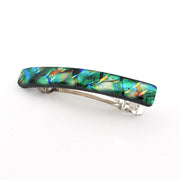 A silver-toned hair barrette with a glossy, rectangular iridescent green and blue glass inlay featuring orange and yellow reflective flecks, shown on a plain white background.