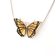 Butterfly-shaped pendant on a chain against a white background