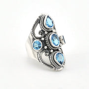 A silver-toned statement ring featuring five light blue gemstones of varying shapes, set against a plain white background.