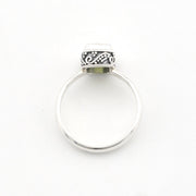 A sterling silver ring with a flat band and a decorative, oxidized scrollwork top setting, shown on a plain white background.