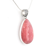 A teardrop-shaped pink gemstone pendant in a silver bezel setting on a silver chain, shown against a plain white background.
