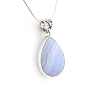 A silver teardrop pendant necklace featuring a light blue and lavender marbled stone, suspended from a delicate silver chain on a white background.