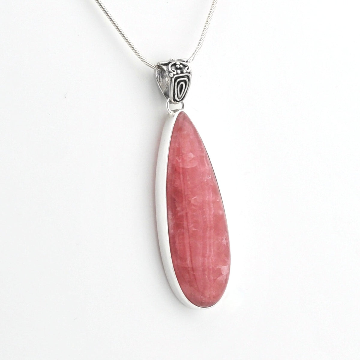 A silver pendant necklace featuring a teardrop-shaped pink stone, shown against a plain white background.