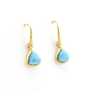 A pair of gold drop earrings with trillion-shaped light blue stone pendants, shown on a plain white background.