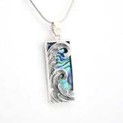 Silver wave pendant with abalone shell inlay on a white background