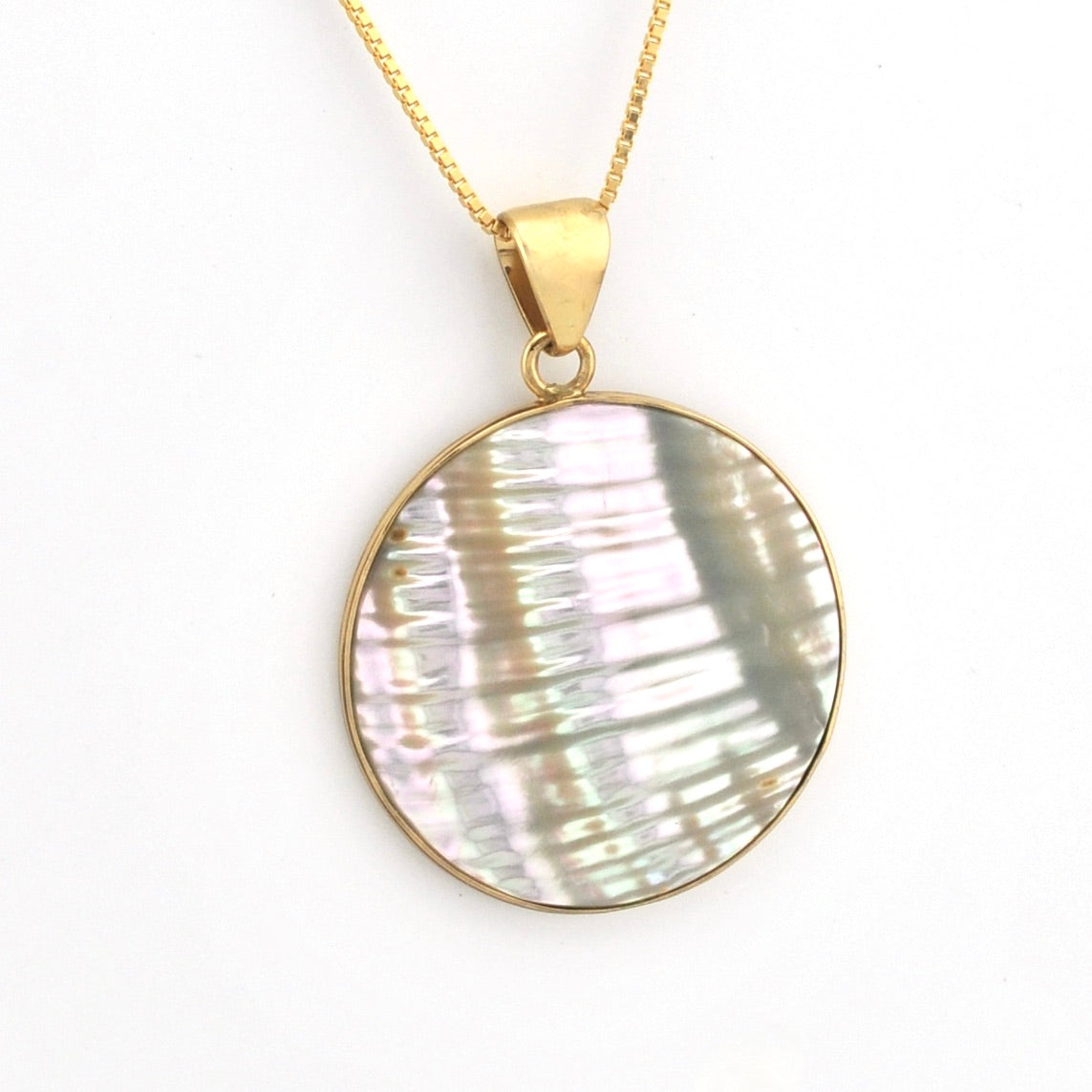 Necklace with a round, shell-like pendant on a gold chain against a white background
