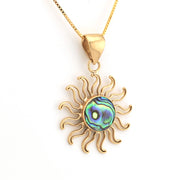Gold sun-shaped pendant with a colorful center on a white background
