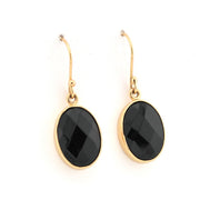 Gold earrings with black stones on a white background