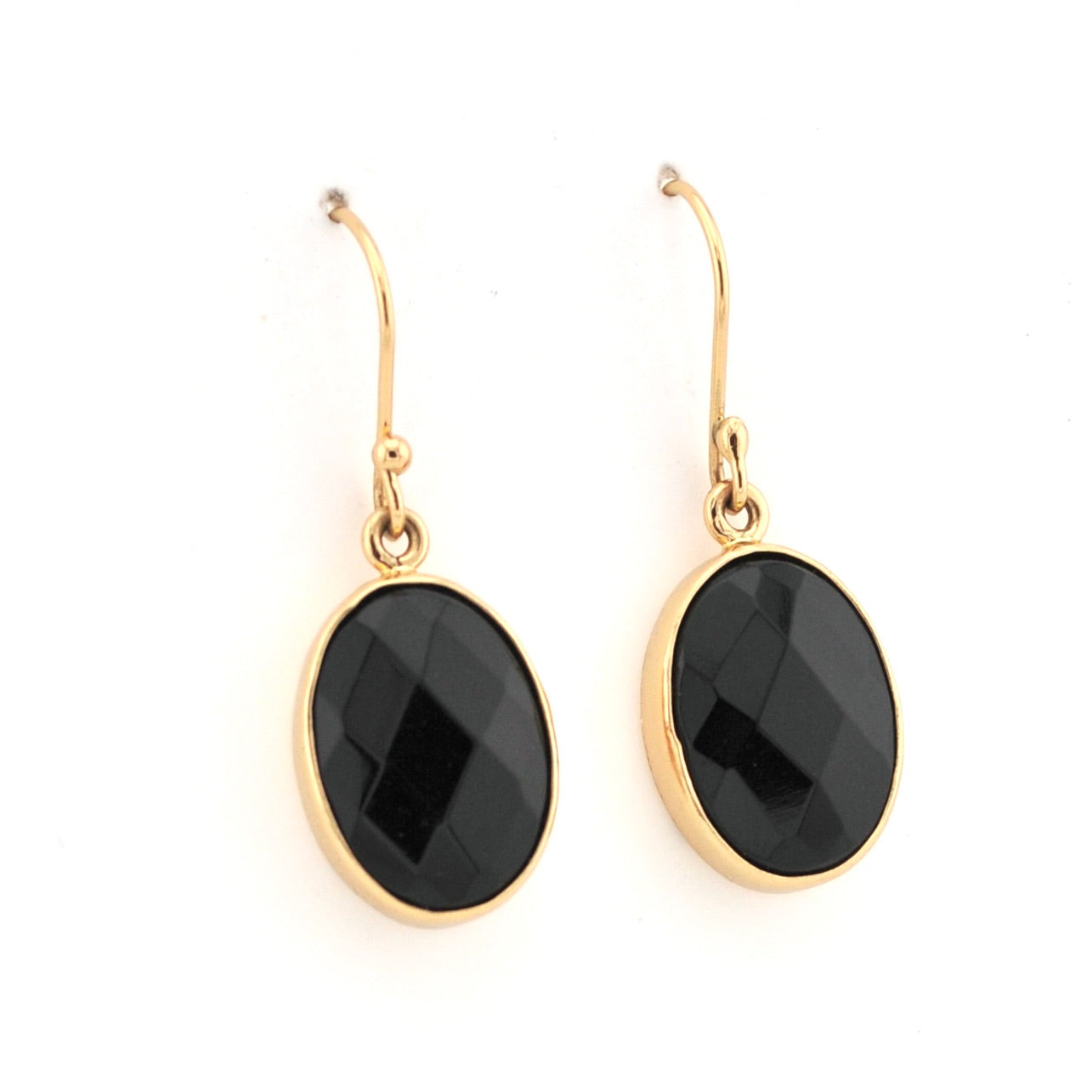 Gold earrings with black stones on a white background