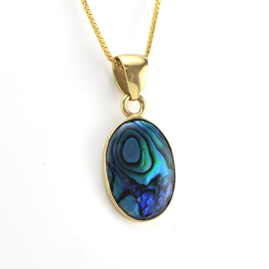 Gold necklace with a blue paua shell pendant on a white background