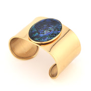 Gold cuff bracelet with a colorful stone on a white background