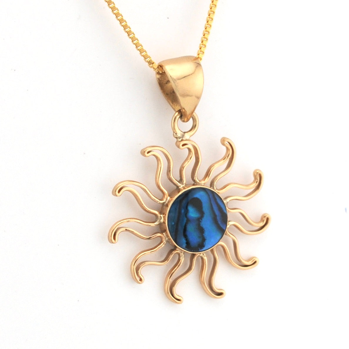 Gold sun-shaped pendant with a blue center on a white background