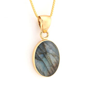 Gold pendant with a blue stone on a white background