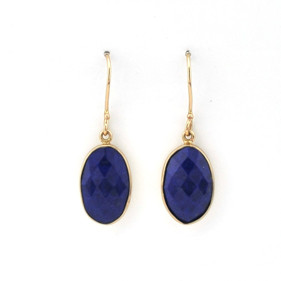 Gold earrings with blue gemstones on a white background