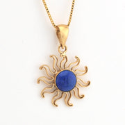 Gold sun-shaped pendant with a blue center on a white background