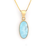 Gold necklace with a blue pendant on a white background