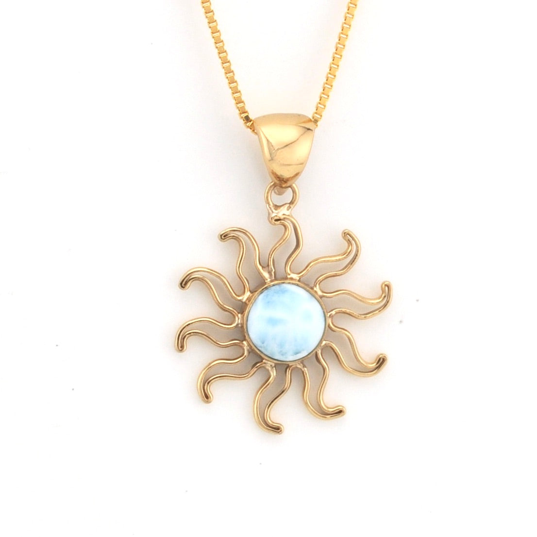 Gold sun-shaped pendant with a light blue center on a white background