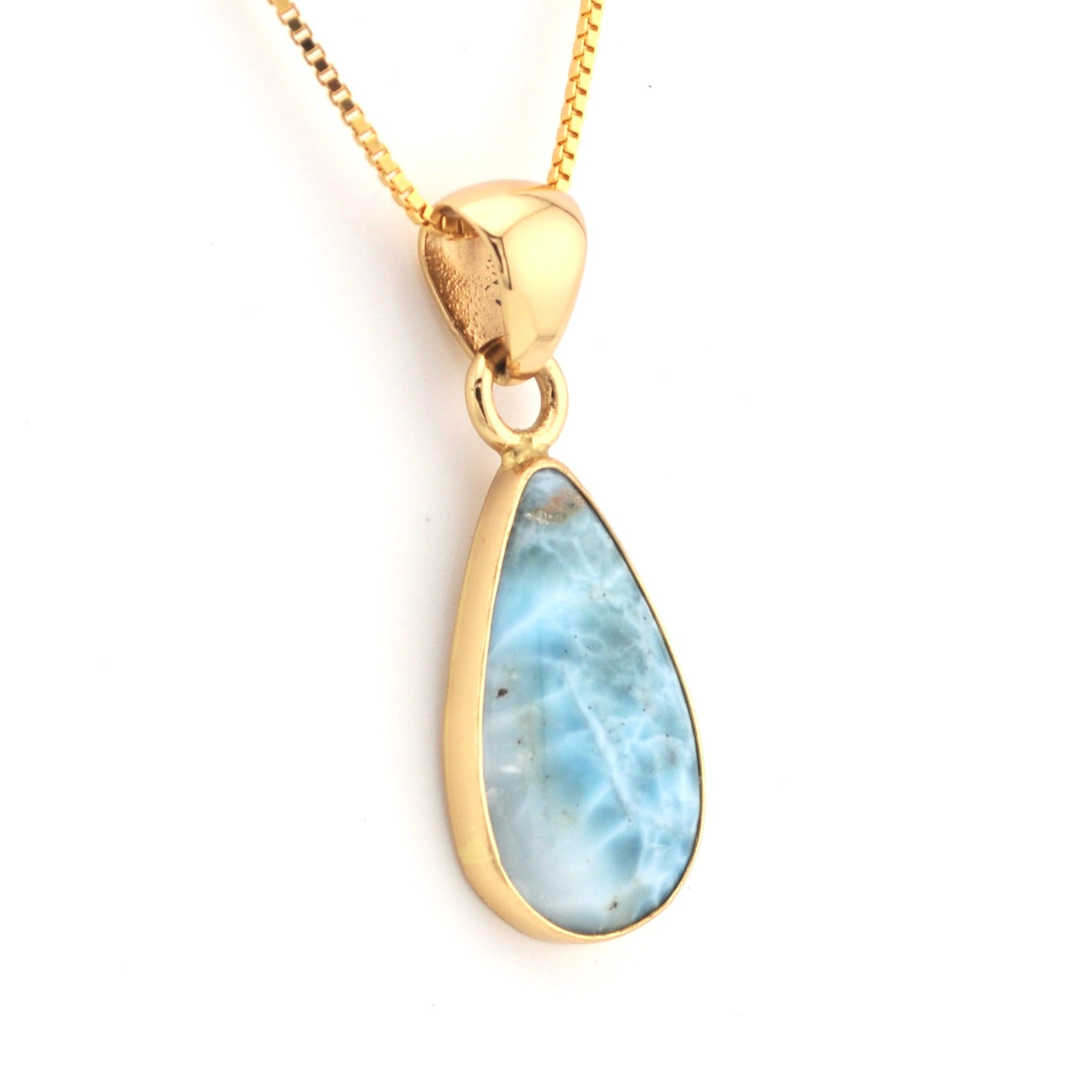 Gold pendant with a blue teardrop-shaped stone on a white background