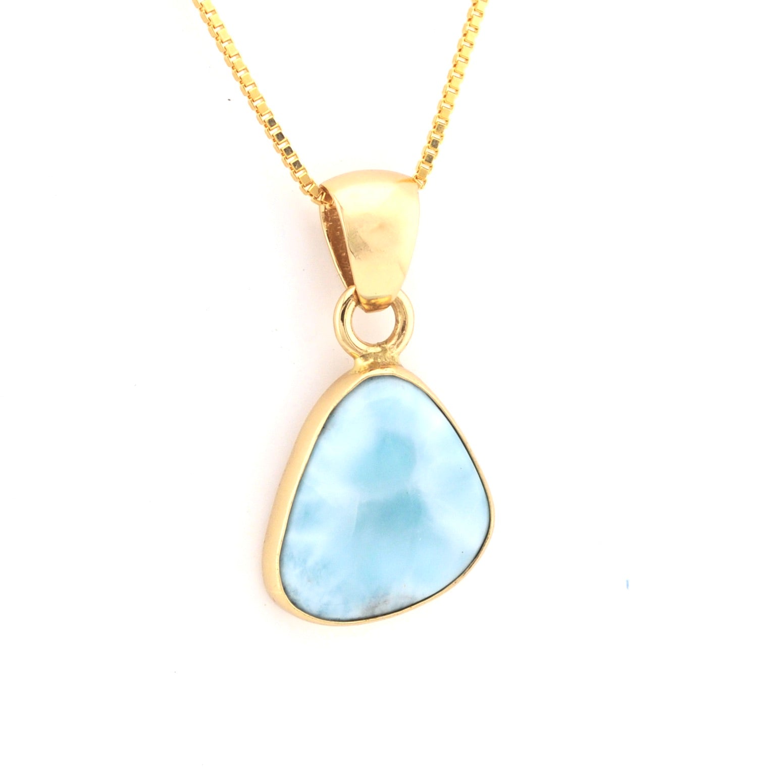 Gold necklace with a blue pendant on a white background
