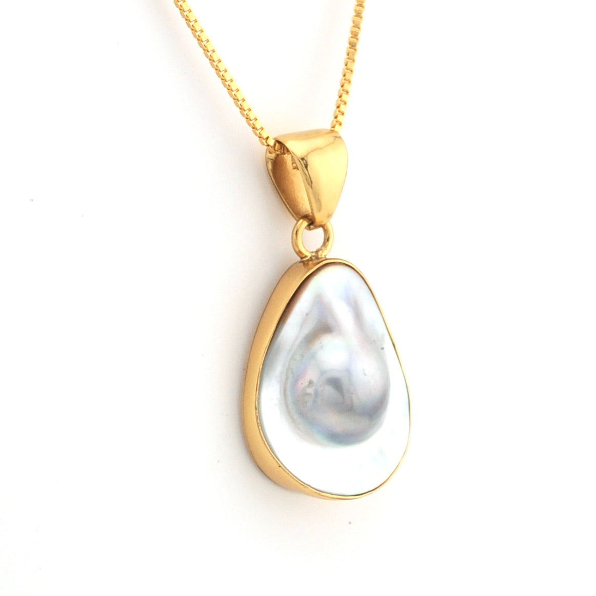 Gold pendant with a large pearl on a white background