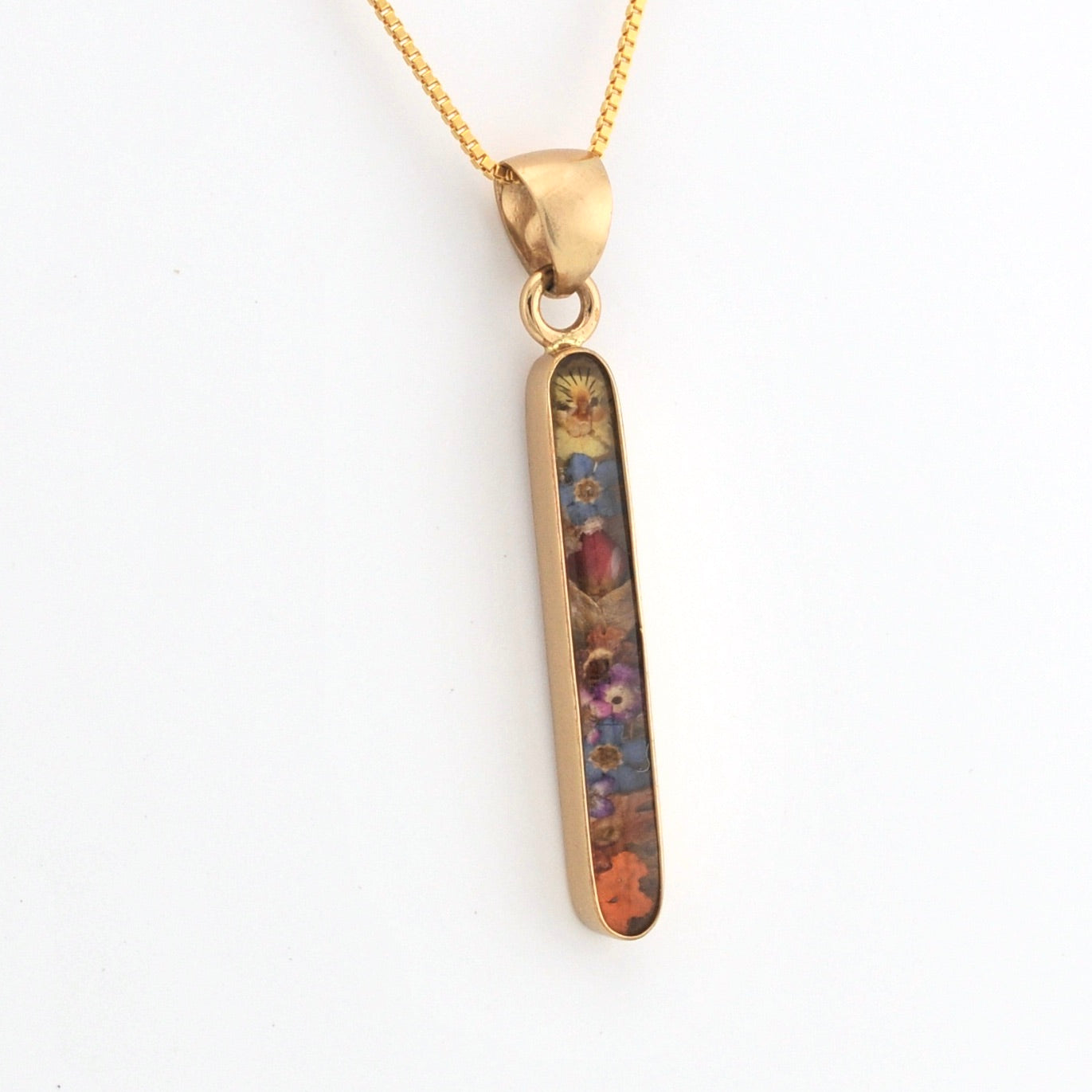 Gold pendant with a colorful inlay on a white background