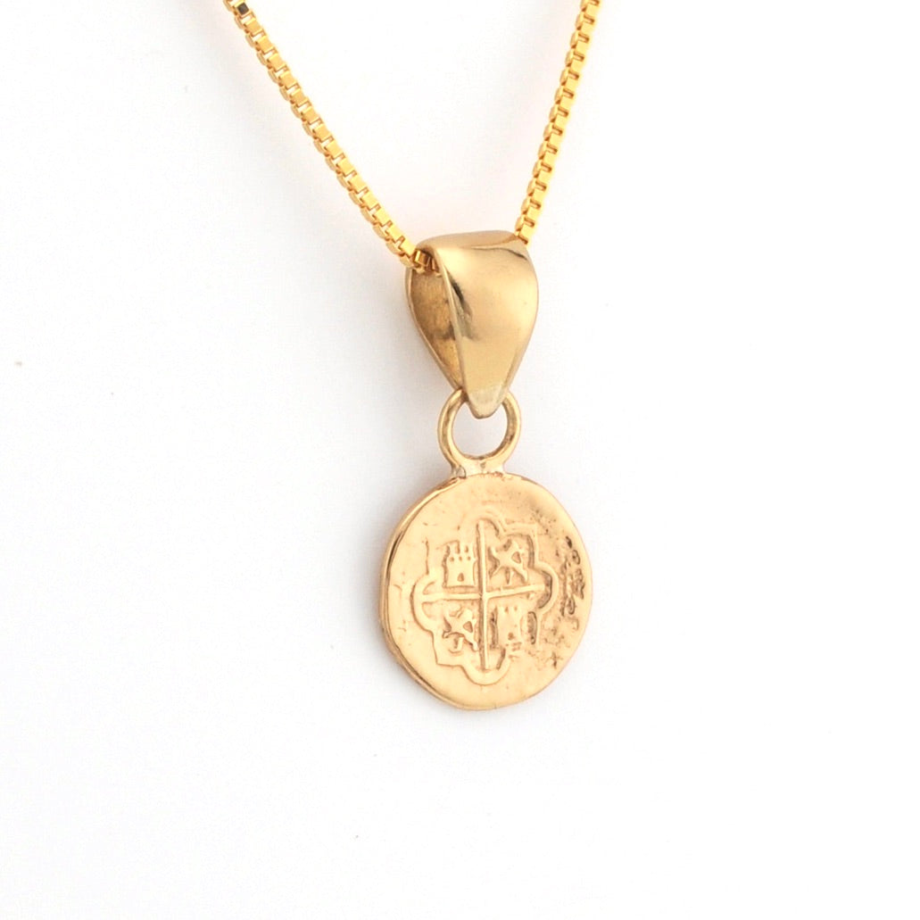 Gold necklace with a round pendant on a white background